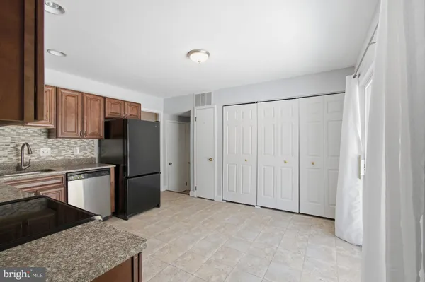 a kitchen with stainless steel appliances granite countertop a refrigerator and a stove top oven