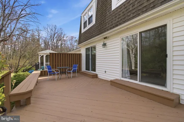 a view of backyard with deck and outdoor seating