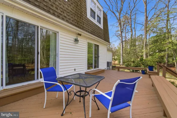 a view of a patio with table and chairs and couches with wooden floor and fence