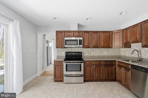 a kitchen with sink a microwave and cabinets