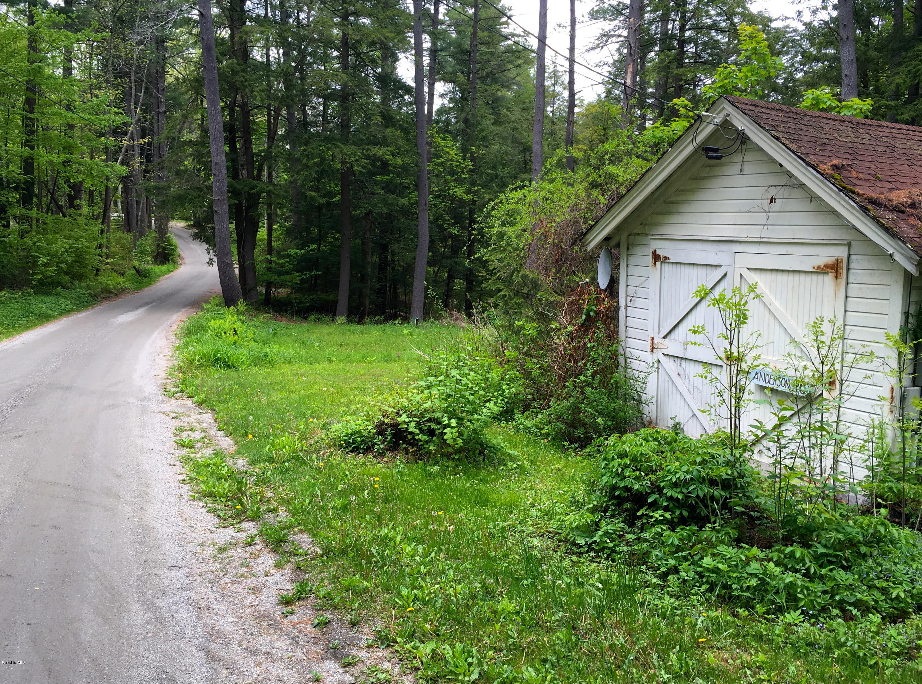 26 Bidwell Road Monterey, MA 01245 - Photo 17 of 17 a view of a wooden house with a small yard and large trees