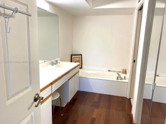 a bathroom with a tub sink and a mirror