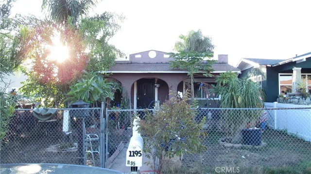 a front view of a house with a tree