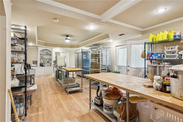 a room with stainless steel appliances kitchen island granite countertop a table chairs and a refrigerator