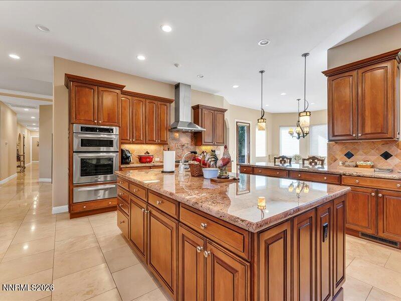 1120 Zolezzi Lane Reno, NV 89511 - Photo 22 of 48 a kitchen with kitchen island granite countertop a stove sink and cabinets