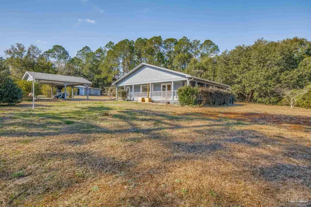 a view of an empty room with wooden floor and a fireplace