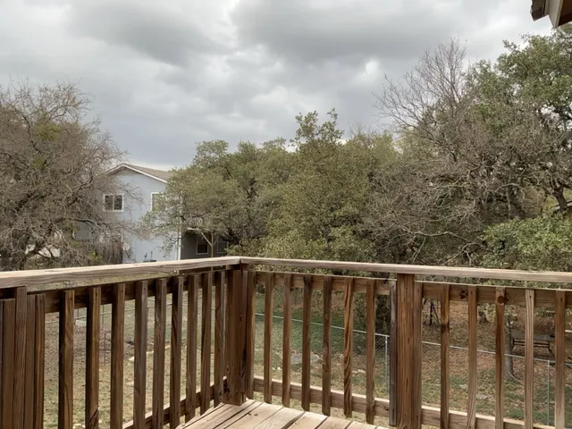 a balcony with wooden floor and fence