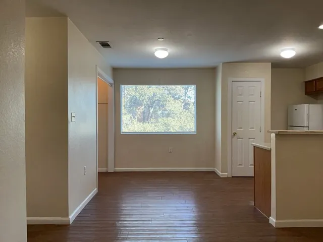 an empty room with wooden floor and a window