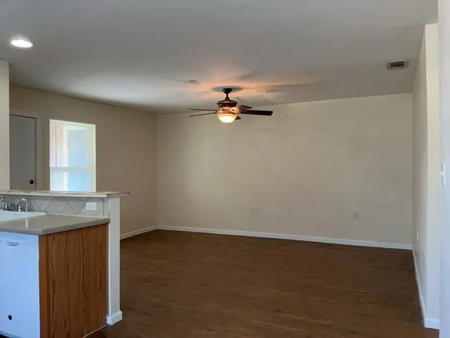 a view of a kitchen with a sink dishwasher a refrigerator with wooden cabinets