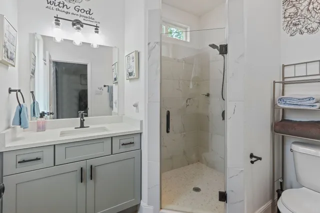 a bathroom with a shower sink vanity and mirror
