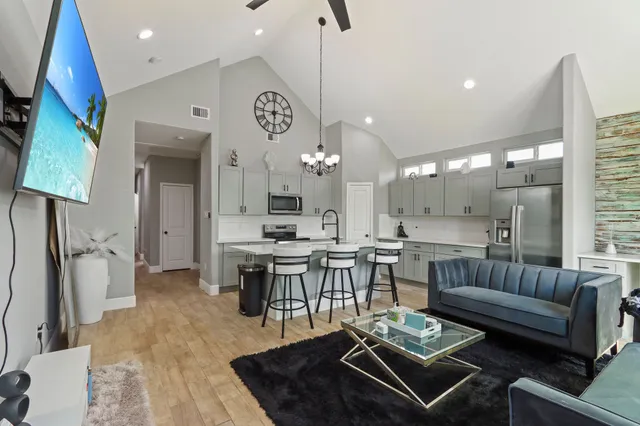 a living room with furniture a rug and kitchen view