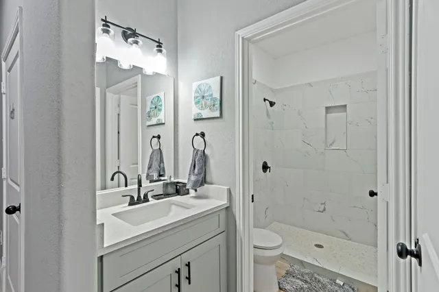 a bathroom with a sink a toilet and shower