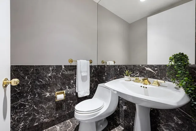 a bathroom with a granite countertop sink a toilet and shower