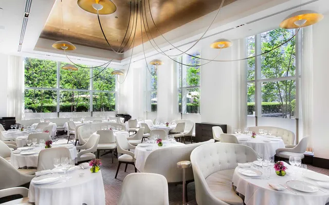 a very nice looking dining room with a large window and chairs