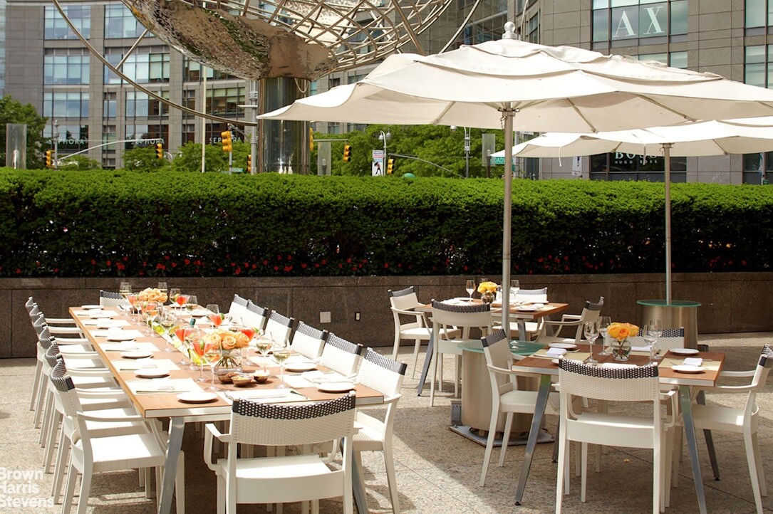 1 Central Park West, Unit 38C Manhattan, NY 10023 - Photo 18 of 24 a view of a patio with table and chairs under an umbrella