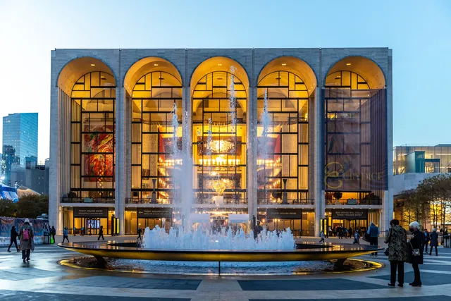 a front view of multi story residential apartment building with outdoor seating