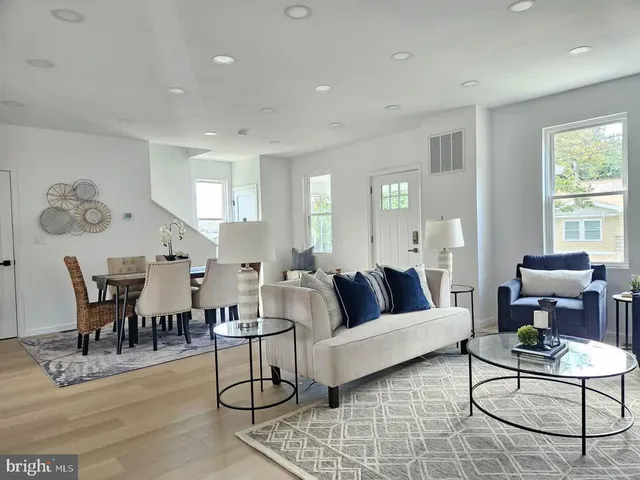 a living room with furniture dining table and a large window