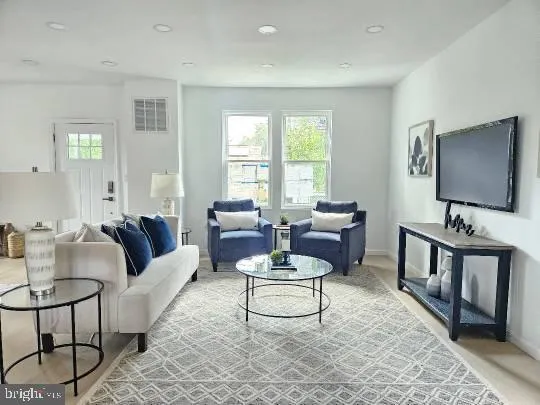 a living room with furniture a rug and a window