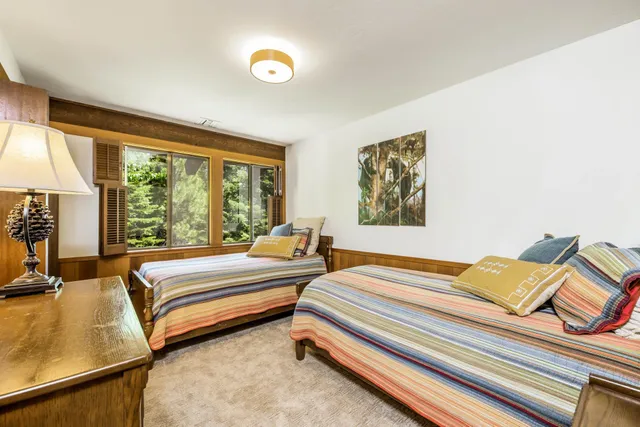 a bedroom with two beds and a large window