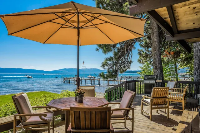 a view of deck with patio table and chairs under an umbrella