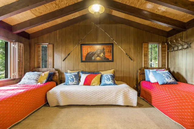 a bedroom with two beds and a painting on the wall