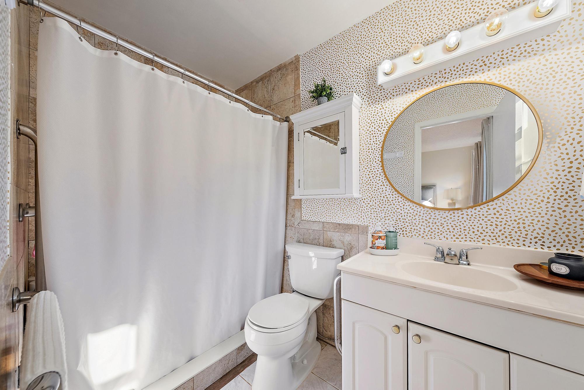 16766 123rd Terrace North Jupiter, FL 33478 - Photo 14 of 26 a bathroom with a sink a mirror a toilet and a shower curtain