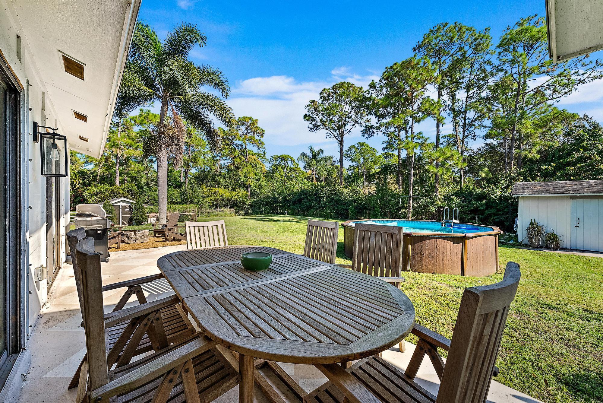 16766 123rd Terrace North Jupiter, FL 33478 - Photo 19 of 26 a view of an outside dining space with furniture and garden