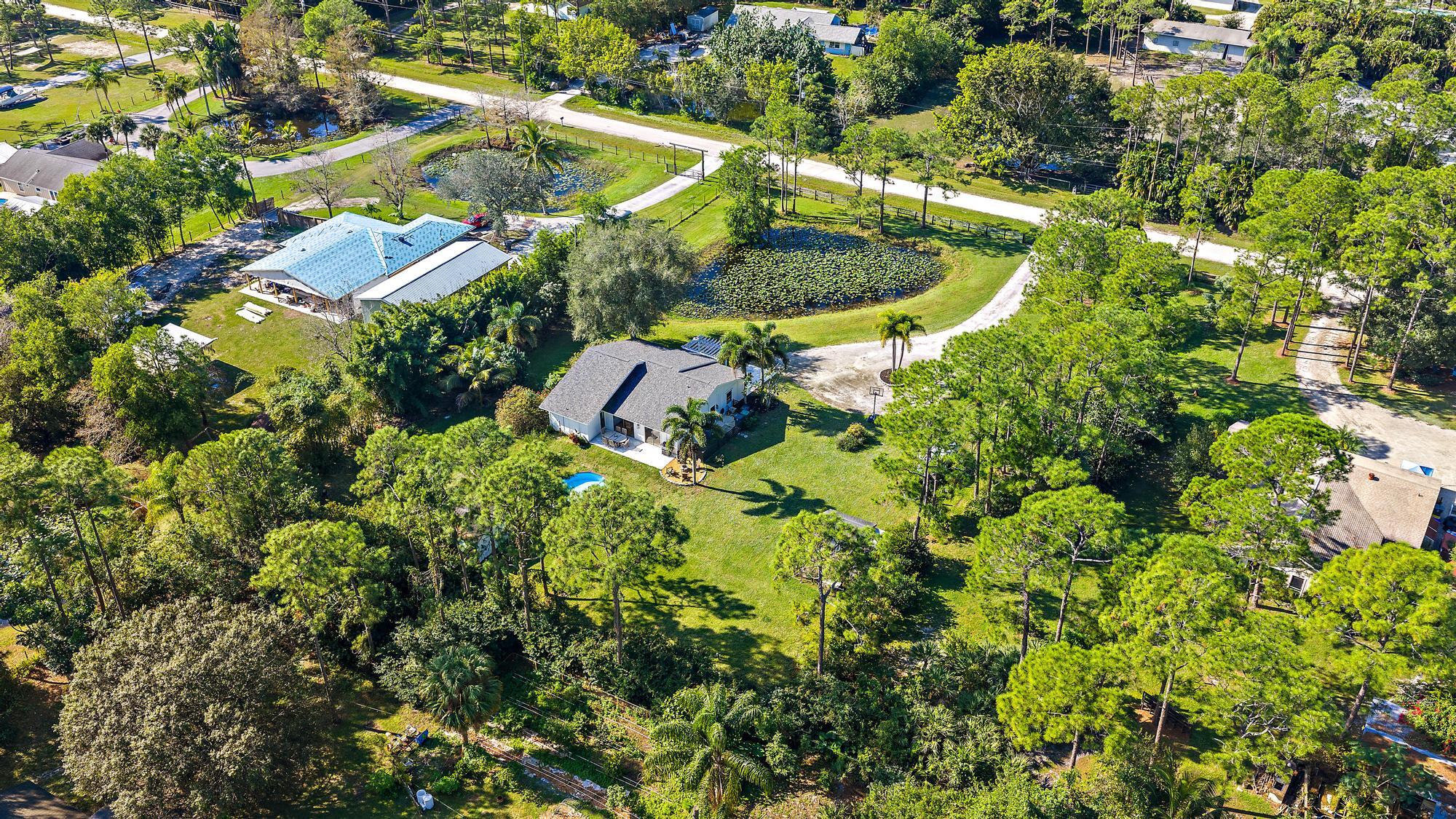 16766 123rd Terrace North Jupiter, FL 33478 - Photo 25 of 26 a view of a house with a swimming pool and lawn chairs
