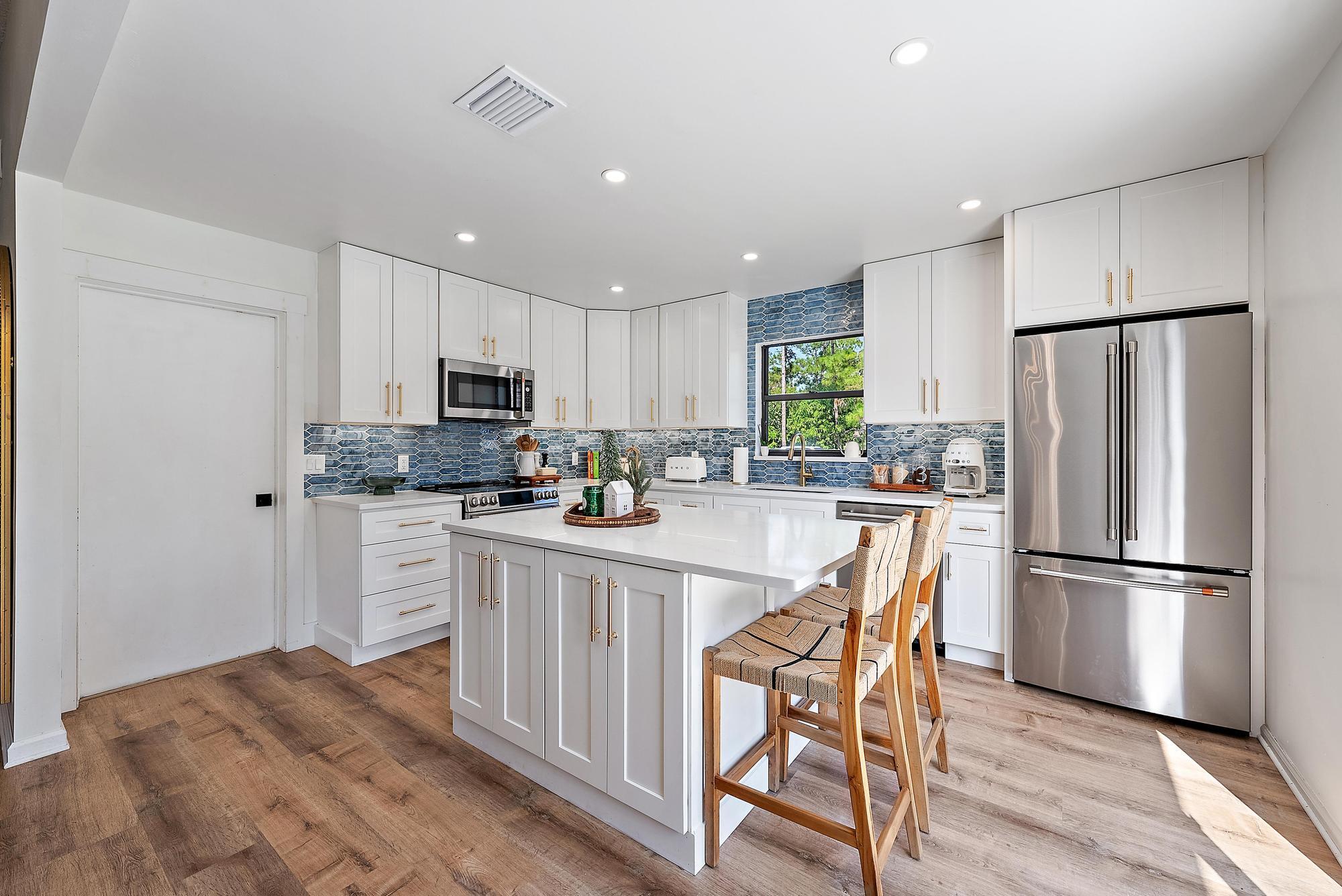 16766 123rd Terrace North Jupiter, FL 33478 - Photo 4 of 26 a kitchen with stainless steel appliances granite countertop a refrigerator stove microwave and cabinets