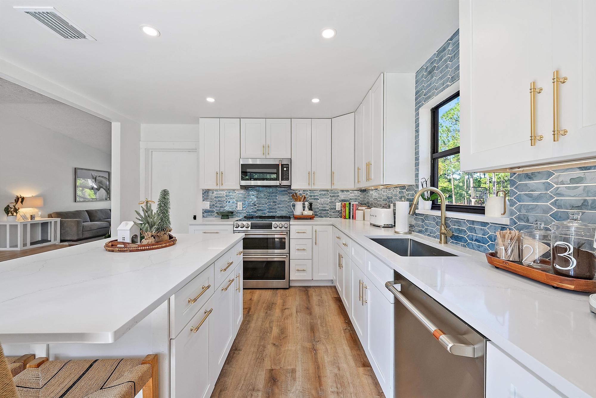 16766 123rd Terrace North Jupiter, FL 33478 - Photo 6 of 26 a kitchen with stainless steel appliances kitchen island granite countertop a sink stove cabinets and a refrigerator