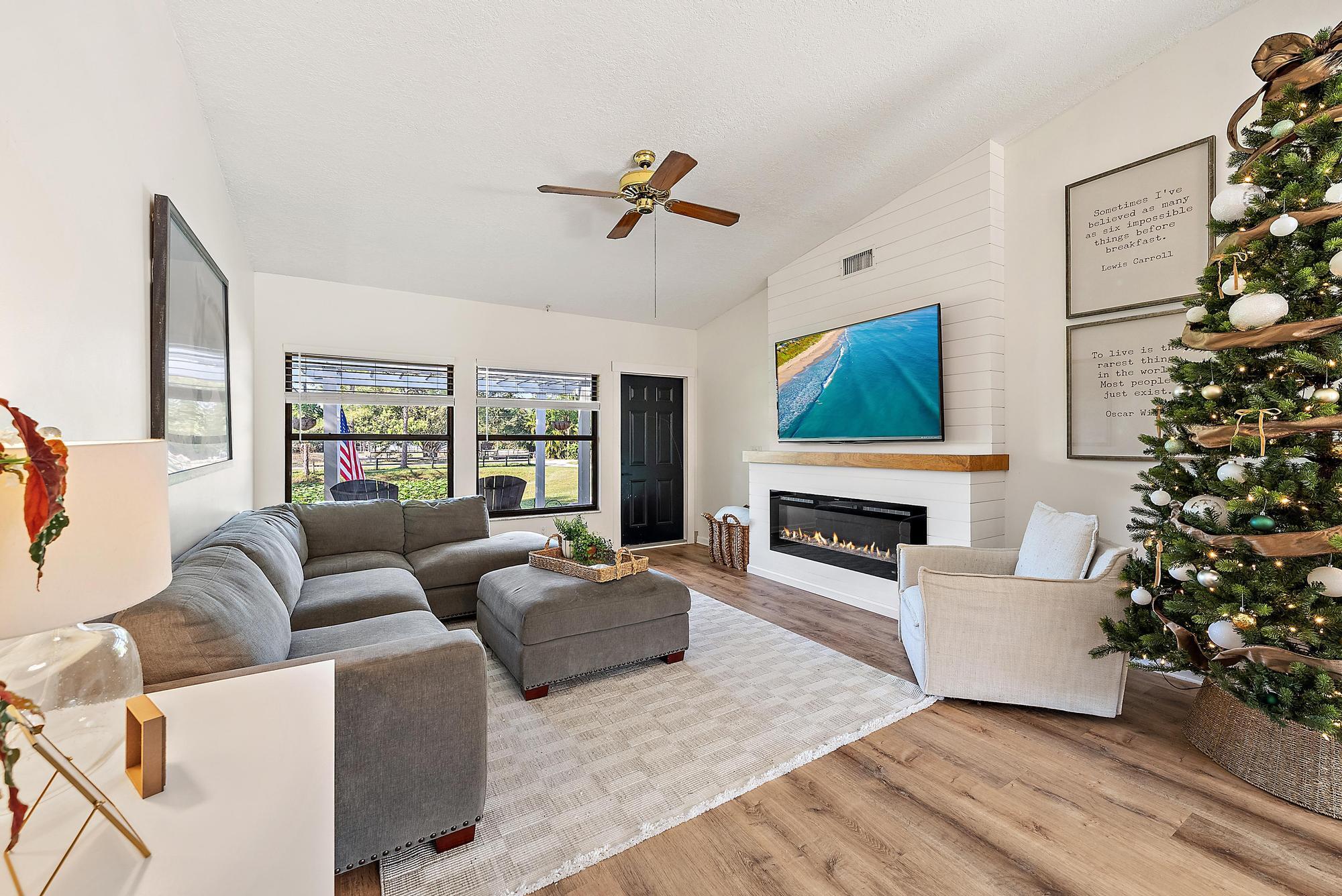 16766 123rd Terrace North Jupiter, FL 33478 - Photo 8 of 26 a living room with furniture a fireplace and a flat screen tv