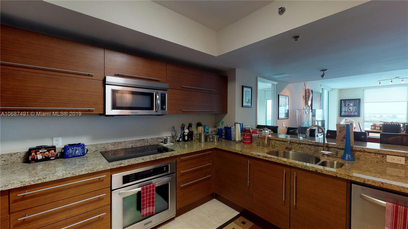 2641 North Flamingo Road, Unit 1401N Plantation, FL 33323 - Photo 23 of 49 a kitchen with stainless steel appliances a sink dishwasher stove microwave and cabinets