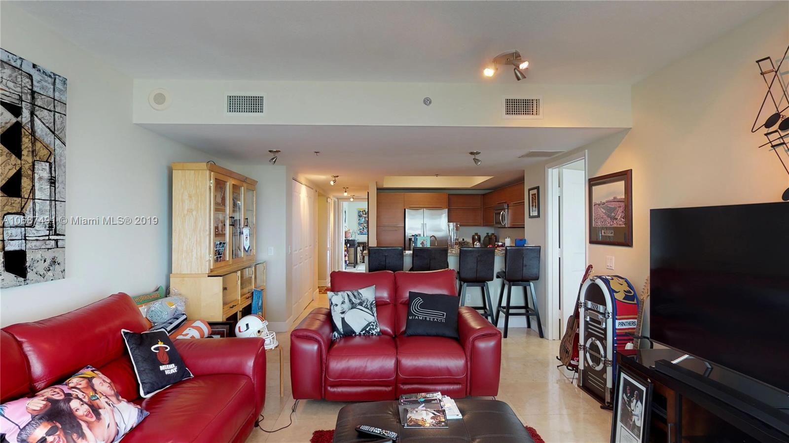 2641 North Flamingo Road, Unit 1401N Plantation, FL 33323 - Photo 29 of 49 a living room with furniture a flat screen tv and a refrigerator