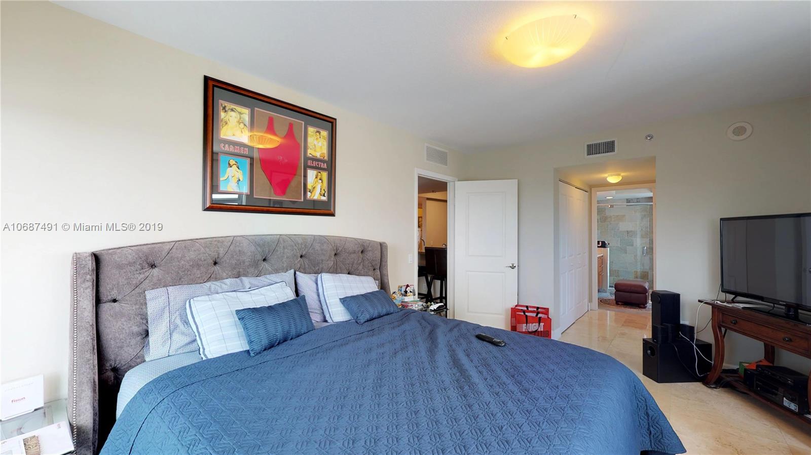 2641 North Flamingo Road, Unit 1401N Plantation, FL 33323 - Photo 34 of 49 a bedroom with a bed and a flat screen tv