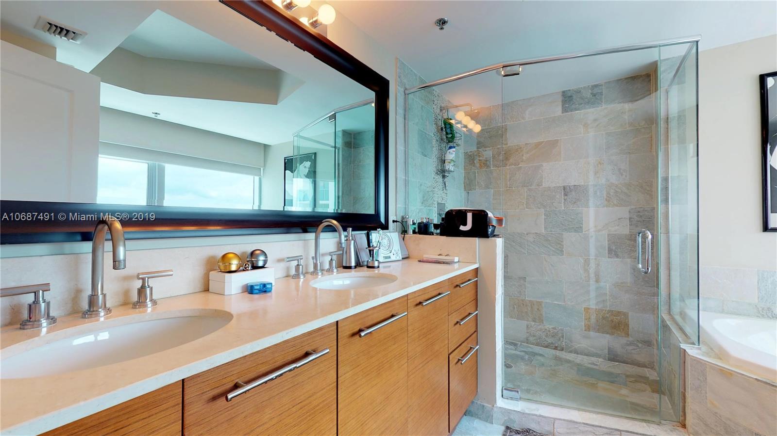 2641 North Flamingo Road, Unit 1401N Plantation, FL 33323 - Photo 36 of 49 a bathroom with a shower sink and mirror