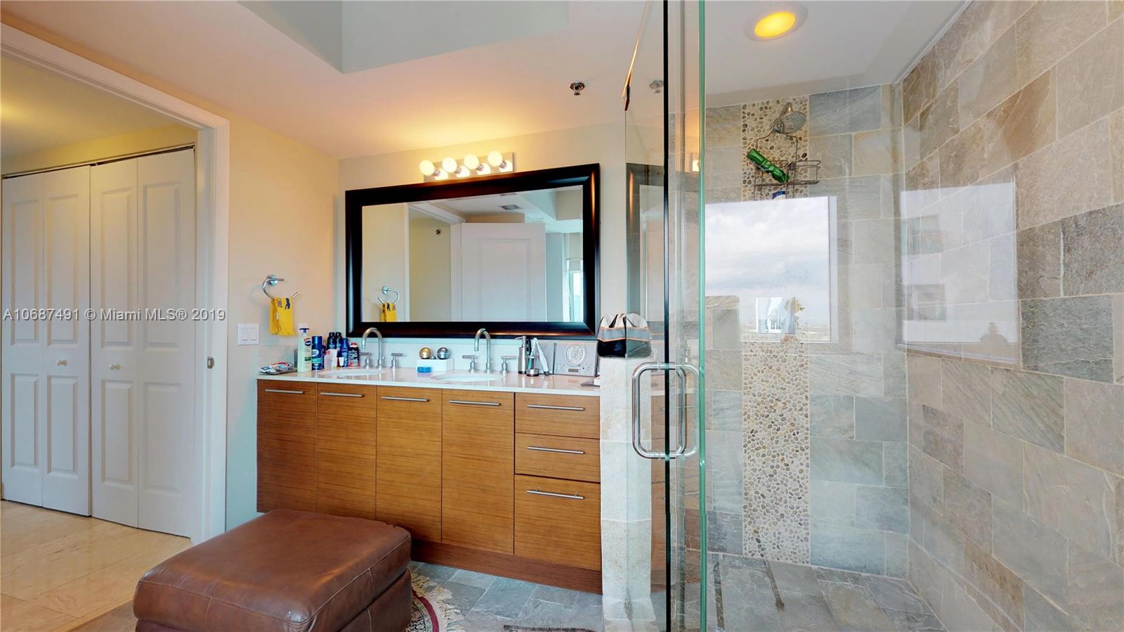 2641 North Flamingo Road, Unit 1401N Plantation, FL 33323 - Photo 38 of 49 a bathroom with a granite countertop sink a mirror and a shower