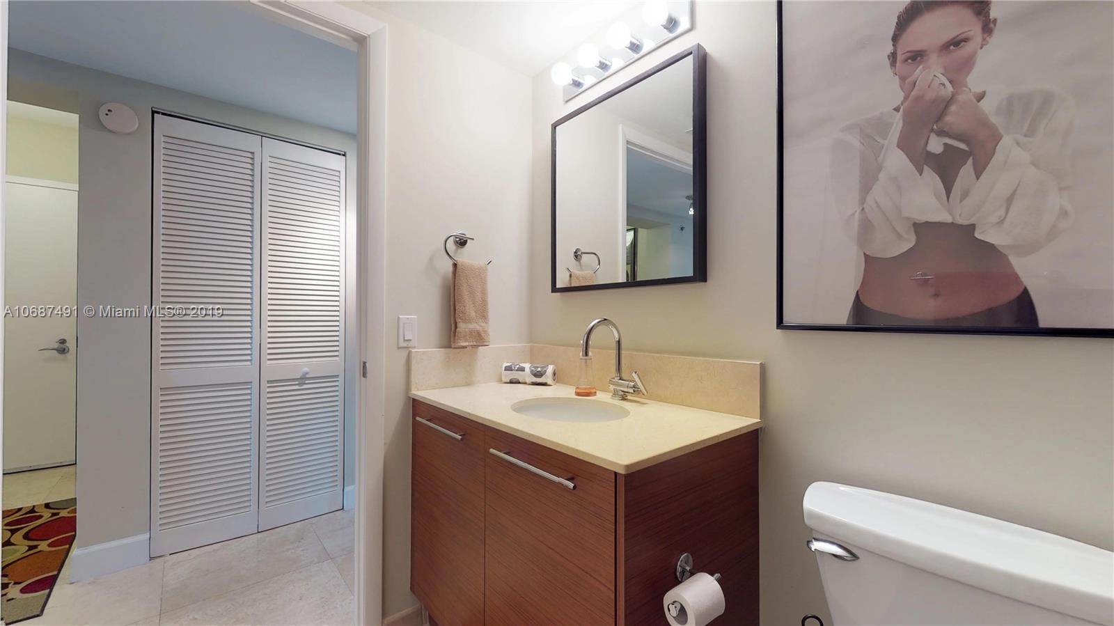 2641 North Flamingo Road, Unit 1401N Plantation, FL 33323 - Photo 42 of 49 a bathroom with a toilet sink and mirror