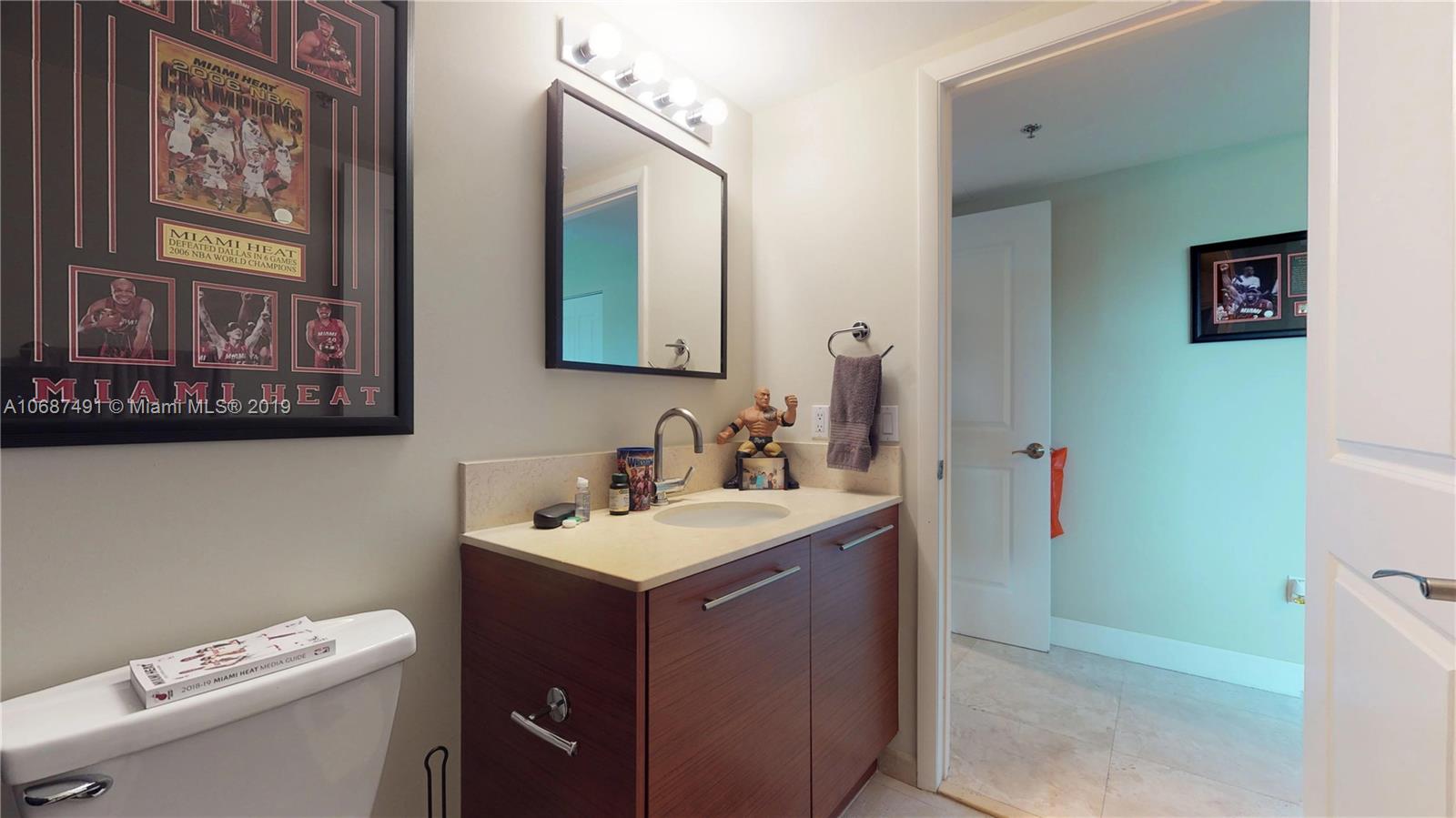 2641 North Flamingo Road, Unit 1401N Plantation, FL 33323 - Photo 47 of 49 a bathroom with a toilet sink and mirror