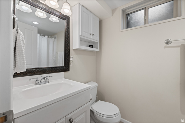 3320 Cherokee Lane Provo, UT 84604 - Photo 34 of 52 Bathroom featuring a white vanity with integrated sink, coordinating white cabinetry, a framed mirror, and a frosted window