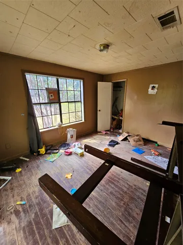 a bedroom with a bed window and a table in it