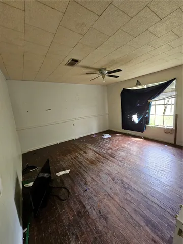 a view of a livingroom with wooden floor and window