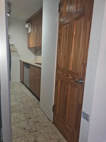 a kitchen with granite countertop a refrigerator and cabinets
