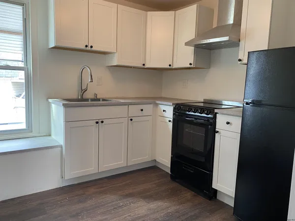 a kitchen with a sink a refrigerator and cabinets