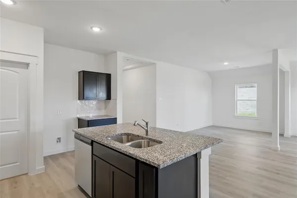 a kitchen with stainless steel appliances granite countertop a sink and dishwasher with wooden floor
