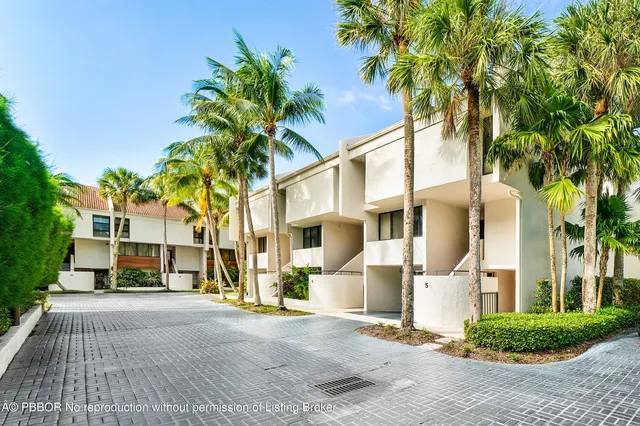 a view of residential houses with palm trees
