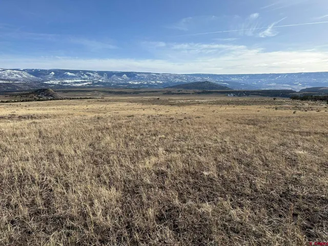 a view of a large building with mountains in the background