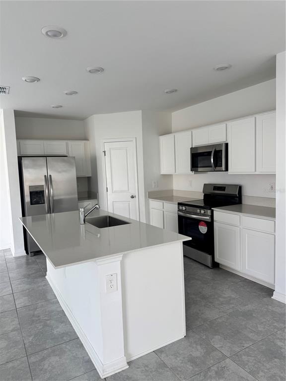 1433 Austin Street Winter Haven, FL 33859 - Photo 4 of 6 a kitchen with granite countertop a refrigerator and a stove top oven
