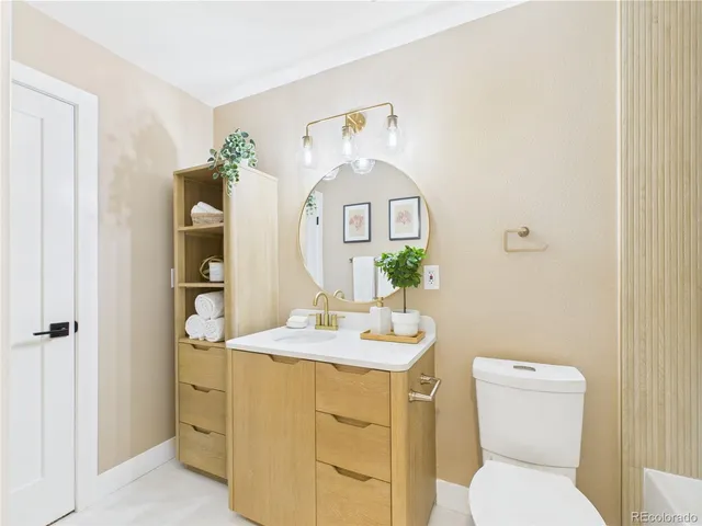 a bathroom with a toilet sink and mirror