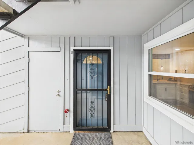 a view of a hallway with wooden cabinet and door
