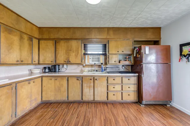 a kitchen with wooden floors and refrigerator